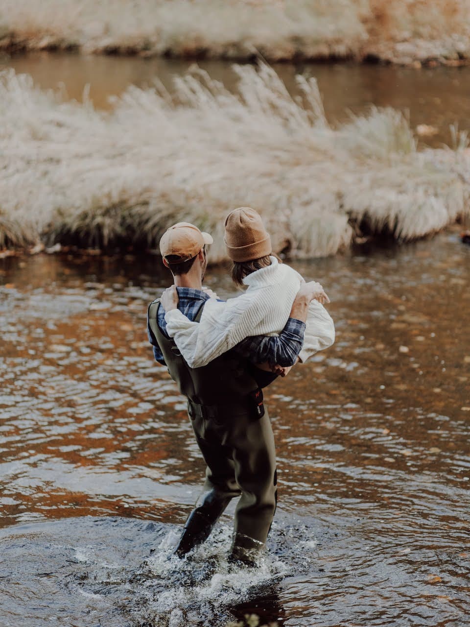 man carrying woman across river